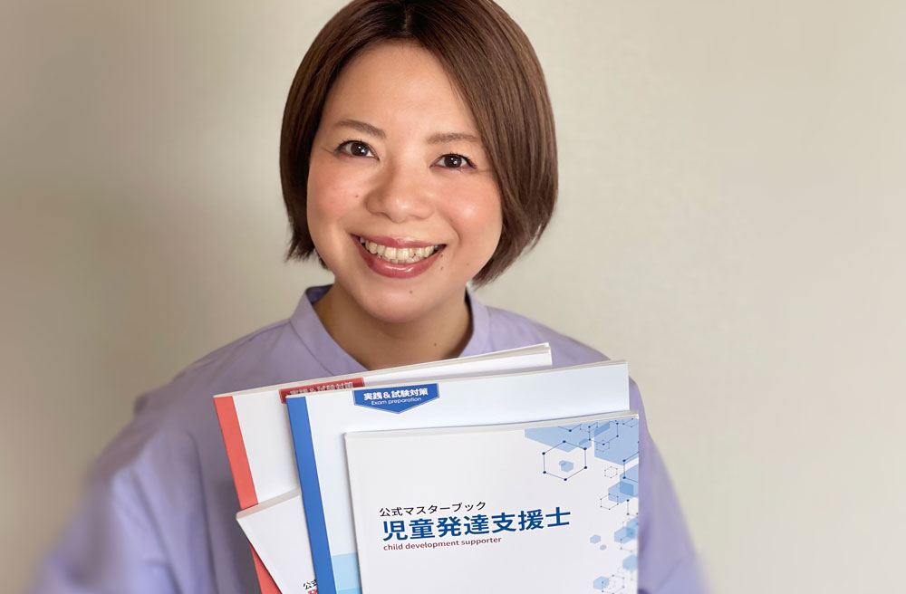 児童発達支援士の公式マスターブックを持つ人間力認定協会スタッフ