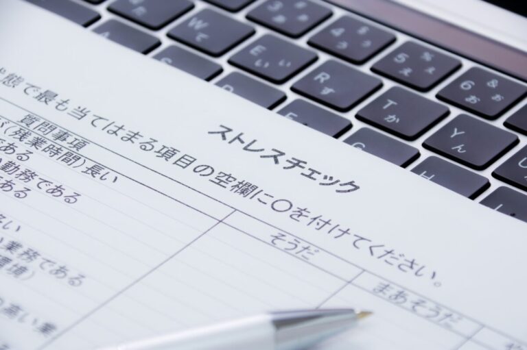 オフィスの窓際でストレスチェックの結果を見ている人（高ストレス者と判定されたら）