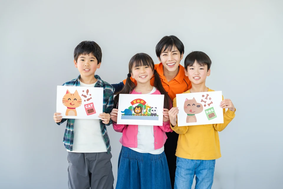 支援者がカードを使って子どもたちとコミュニケーションのトレーニングを行っている様子