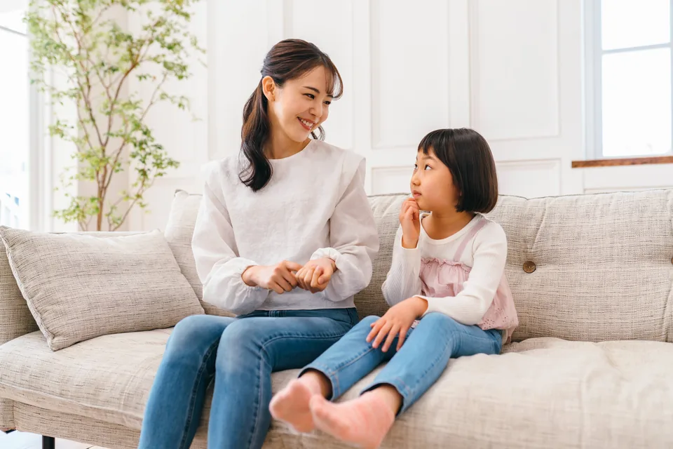 ソファで子どもと向き合って話している母親